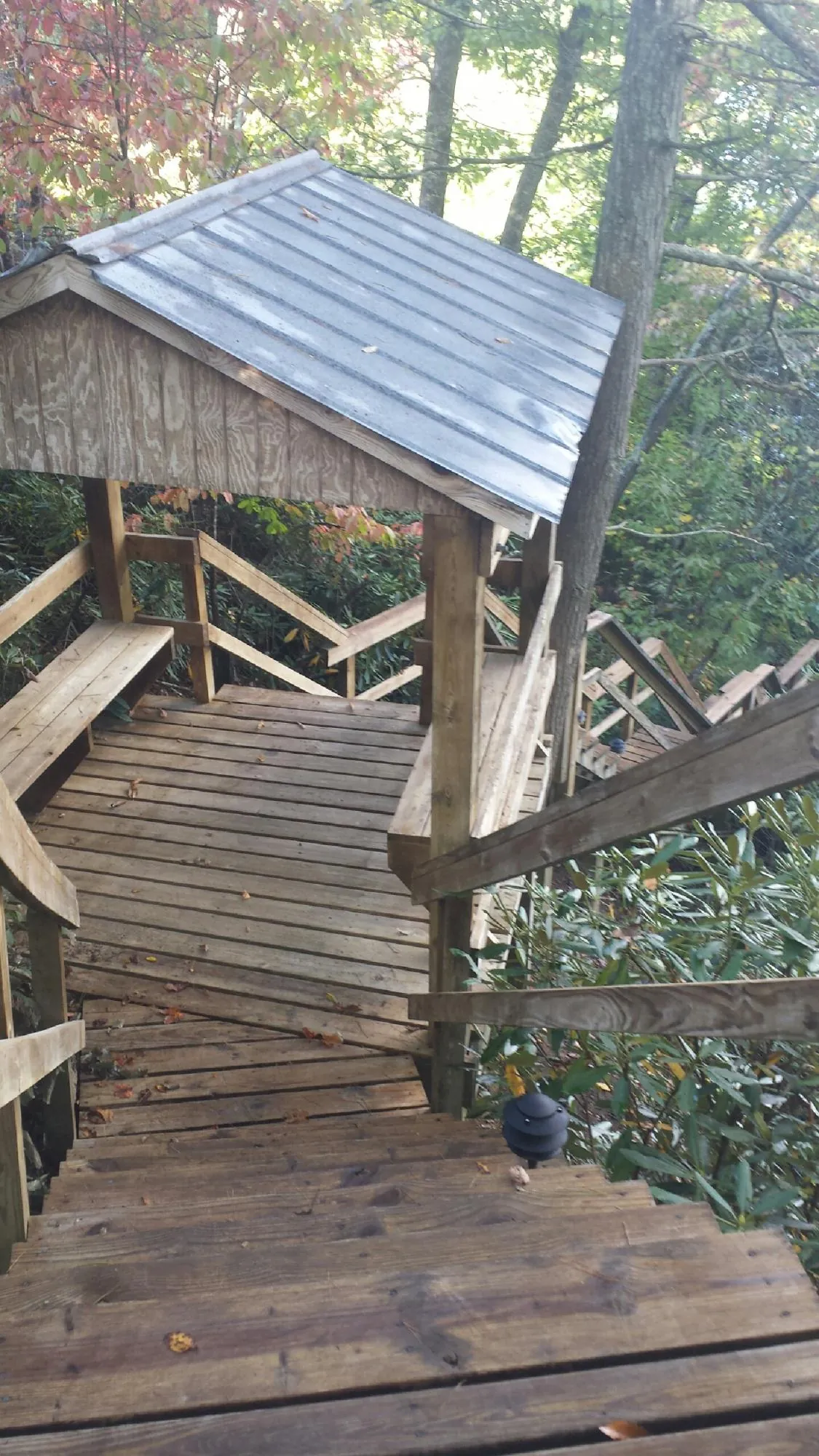 Metal roofed shelter over wooden steps on a wooded walkway — Skylight Repair & Installation work by our crew in Walpole